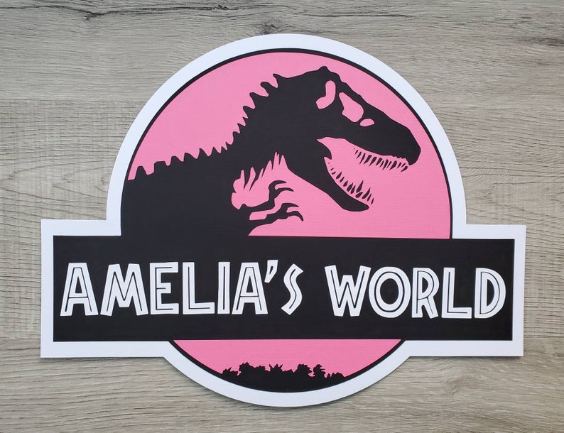 May include: Pink and black sign with a dinosaur silhouette and the text "Amelia's World".