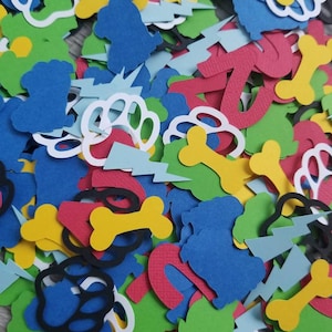 May include: A colorful assortment of paper cutouts in various shapes, including paw prints, dog bones, and lightning bolts. The cutouts are in shades of blue, green, red, yellow, and white, creating a playful and vibrant mix. Ideal for crafting or party decorations.
