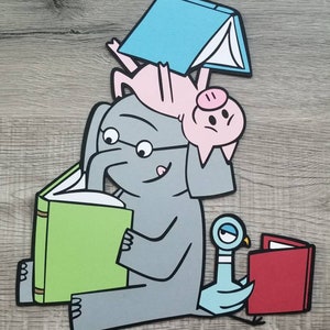 May include: A layered paper cutout illustration featuring a gray elephant wearing glasses and reading a green book, a pink pig balancing a blue book on its back, and a light blue pigeon looking at a red book, all with bold black outlines.
