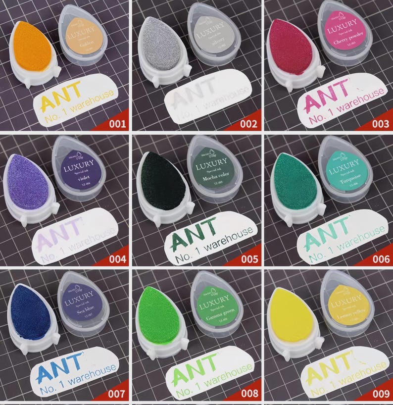 May include: A collection of nine ink pads in various colors, including orange, gray, red, purple, black, green, blue, and yellow. Each pad is paired with a small container labeled "LUXURY" and a label that reads "ANT No. 1 warehouse."