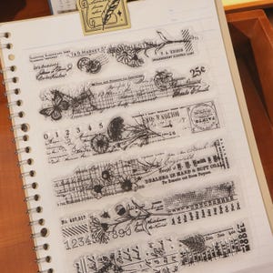 May include: Clear acrylic stamps with vintage designs. The stamps feature botanical illustrations, text, and numbers. Some stamps include text like "7 & 9 Market St" and "Bolton & Sons". Ideal for scrapbooking and crafting projects.