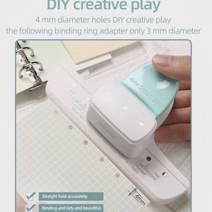 May include: A white and mint green paper hole punch with the text "4MM ORGANIZER". The image also shows a grid-patterned paper with pre-punched holes and the text "4 mm diameter holes DIY creative play".
