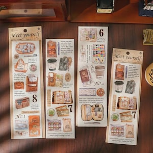 May include: Four vertical sticker sheets labeled Me'et yourself, each featuring various illustrations of stationery, bags, coffee cups, and books. The designs include numbered sections and text snippets, printed on a light beige background with a matte finish.
