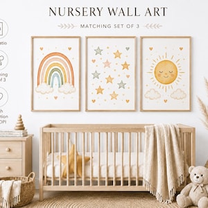 Könnte beinhalten: Ein Set aus drei gerahmten Wandbildern mit Regenbogen, Sternen und Sonne. Der Text lautet NURSERY WALL ART, MATCHING SET OF 3, 2:3 Ratio und High Definition 300 DPI. Die Bilder sind über einem hölzernen Kinderbett an der Wand angebracht.