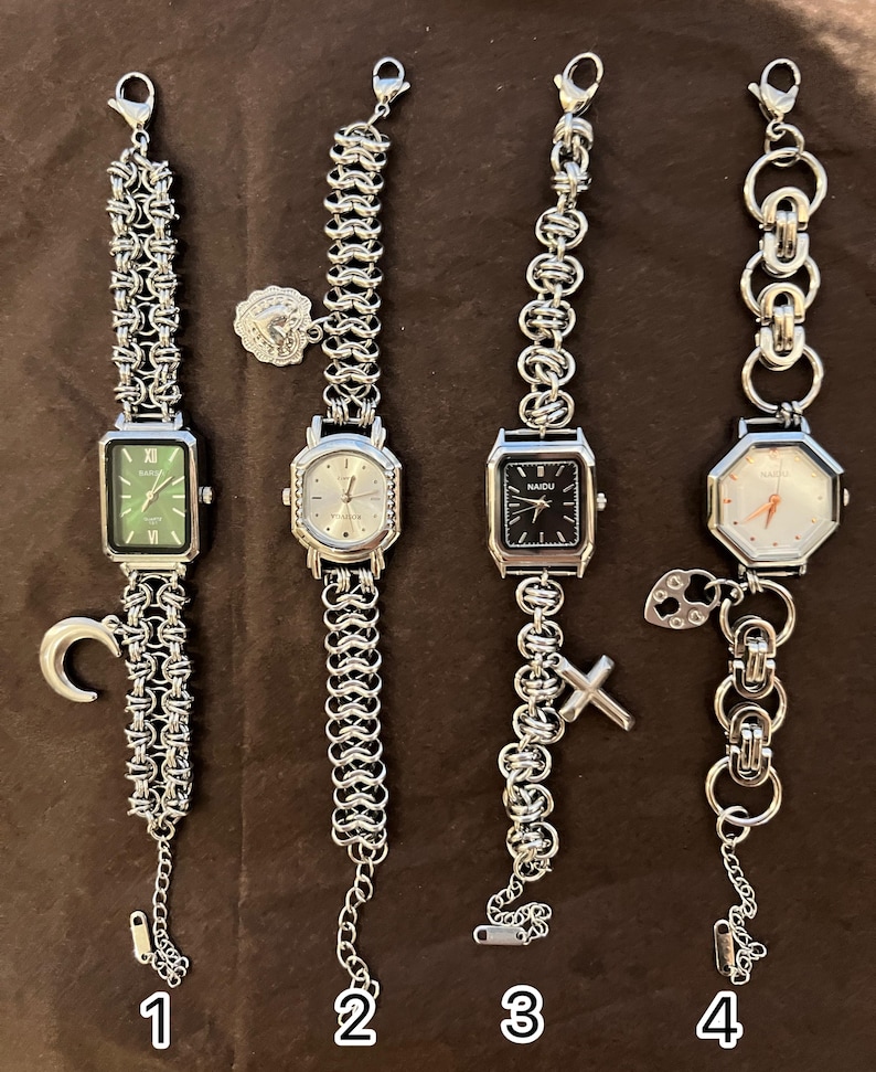 May include: Four silver-toned wristwatches with different chain designs. The watches have rectangular or octagonal faces with various colors, including green, silver, and black. Each watch has a unique charm, such as a crescent moon or a cross.