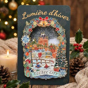 May include: A dark green Christmas card with a winter scene of Quebec City. The card features a detailed illustration of buildings, a bridge, and a Christmas tree, with the words "Lumière d'hiver" and "Quebec City".