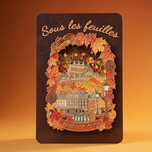 May include: A rectangular pin featuring a detailed illustration of Quebec City in autumn colors. The pin includes text that reads "Sous les feuilles" and "Quebec City". The design is framed by fall leaves and a squirrel.
