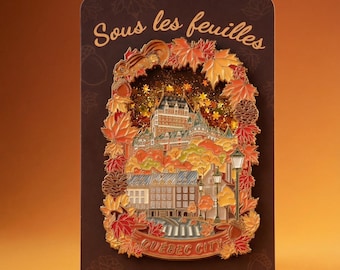 May include: A rectangular pin featuring a detailed illustration of Quebec City in autumn colors. The pin includes text that reads "Sous les feuilles" and "Quebec City". The design is framed by fall leaves and a squirrel.
