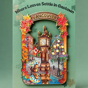 May include: A metal enamel pin featuring the Vancouver Gastown steam clock, surrounded by autumn maple leaves. The pin displays the text "Where Leaves Settle in Gastown", "VANCOUVER", and "WATER ST GASTOWN". A small beaver with a colorful umbrella stands nearby.