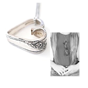 May include: A silver heart-shaped pendant necklace made from a vintage spoon. The pendant has a floral design and is attached to a silver chain.