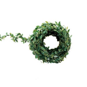 May include: A rolled-up, artificial green leaf garland with a circular shape. The garland is made of small, dark green leaves and is set against a white background. The garland is suitable for home decor and craft projects.