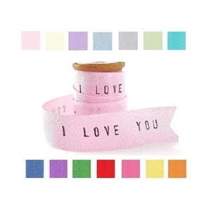 May include: Pink ribbon with the words "I LOVE YOU" printed in black. The ribbon is rolled up, with the text visible on the outer layer. A variety of pastel color swatches are above and below the ribbon.