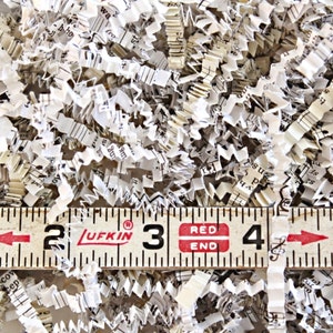 Shredded paper made from old hymnals. The paper is a mix of ivory and cream colors.