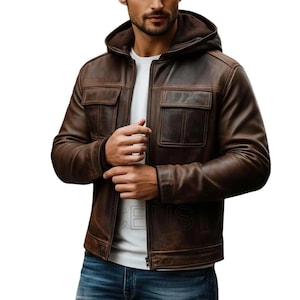 May include: Brown leather jacket with a hood and two front pockets. The jacket has a zipper closure and a soft lining. The model is wearing a white t-shirt and blue jeans. The jacket is a classic style.