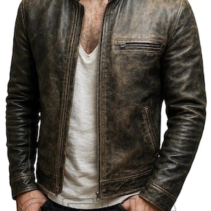 May include: A distressed brown leather jacket with a stand-up collar and a zip-up front. The jacket has a weathered appearance, with a subtle sheen and a chest pocket. The sleeves are long and fitted. A classic outerwear piece.