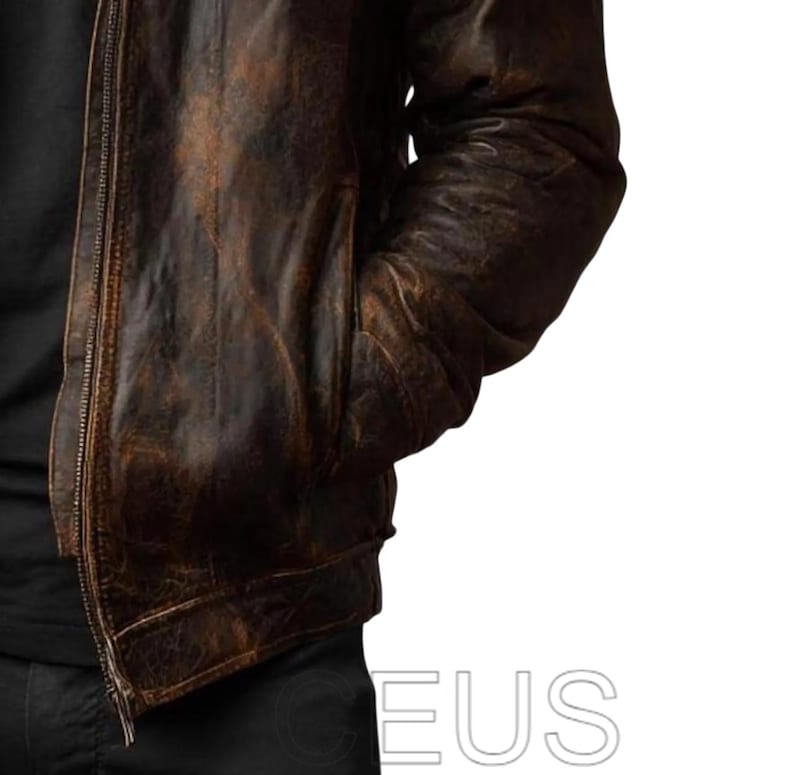 May include: A brown leather jacket with a distressed, vintage appearance. The jacket has a zip closure and pockets. The leather has a worn, textured look with colour variations, suggesting age and use. A classic outerwear piece.