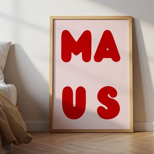 Könnte beinhalten: Ein gerahmter Kunstdruck mit dem Wort "MAUS" in fetten roten Buchstaben auf hellrosa Hintergrund. Das Kunstwerk wird in einem Raum mit einem Bett, einer Vase mit getrockneten Pflanzen und einem kleinen Stapel Bücher ausgestellt.