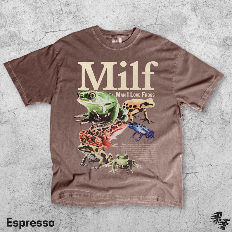 May include: Espresso-colored t-shirt featuring the word "Milf" in large, white letters above a graphic of several colorful frogs. The phrase "Man I Love Frogs" is printed below the word "Milf".