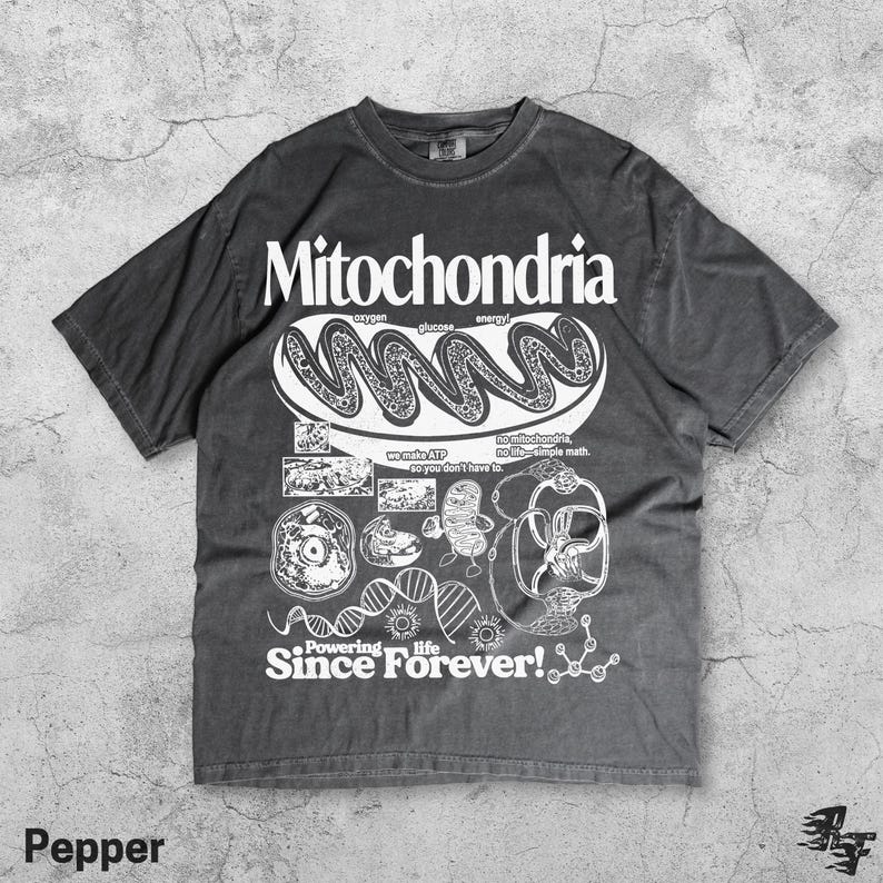 May include: Pepper-colored t-shirt with a white graphic design featuring the word "Mitochondria" and related illustrations. The design includes text that reads "Powering life Since Forever!" and other scientific terms.