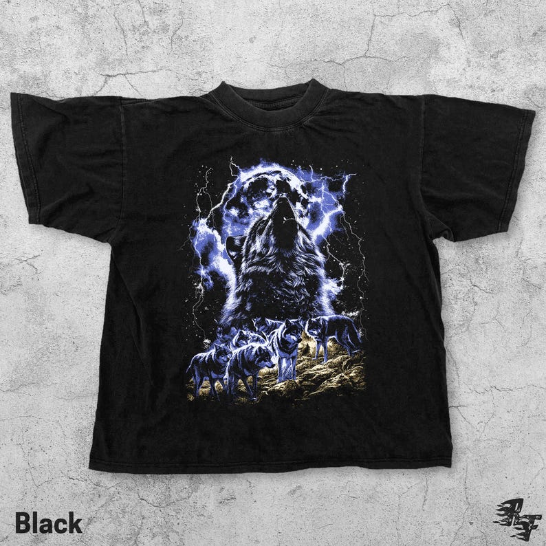 Puede incluir: Camiseta negra con un gr&aacute;fico de un lobo aullando sobre un fondo de tormenta el&eacute;ctrica. El dise&ntilde;o incluye varios lobos en un entorno forestal. La palabra "Black" est&aacute; impresa en la parte inferior de la camiseta.