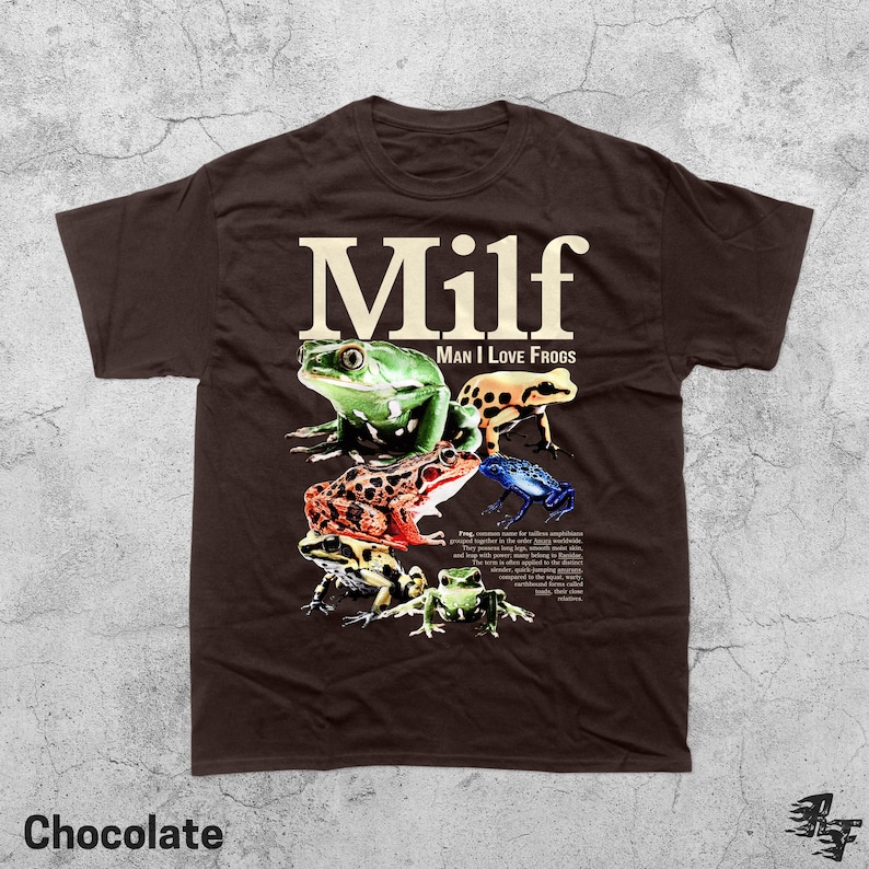 May include: Chocolate-colored t-shirt featuring the word "Milf" in large, white letters above a graphic of several colorful frogs. The text "Man I Love Frogs" is below the word "Milf". The word "Chocolate" is at the bottom.