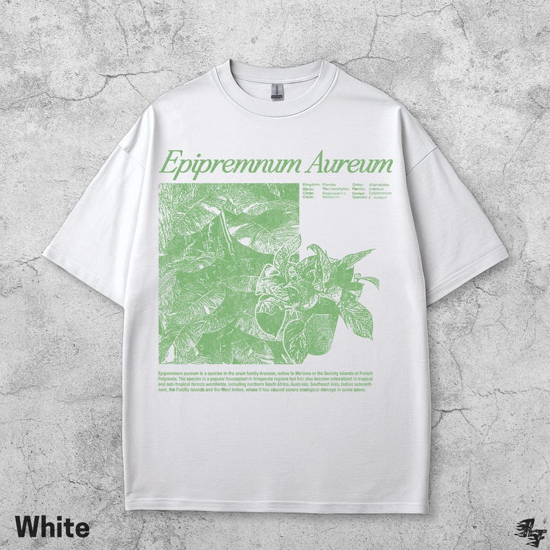 May include: White t-shirt featuring a green botanical illustration of Epipremnum Aureum, with the plant's name in a stylized font. The shirt also includes a description of the plant. The word "White" is printed at the bottom.