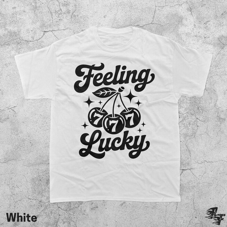 May include: White t-shirt with a black graphic that reads "Feeling Lucky." The design features cherries with the number 7 on each, along with stars and leaves. The word "White" is printed at the bottom.