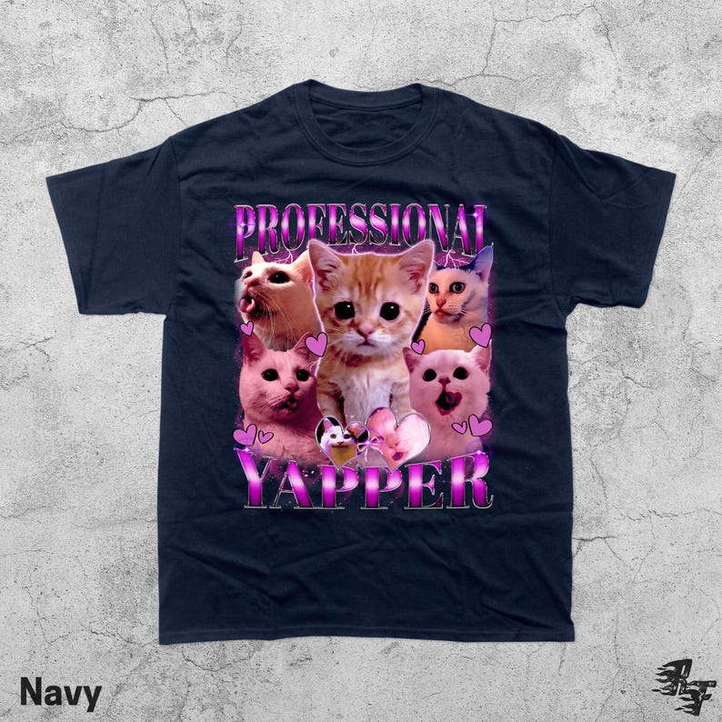 May include: Navy blue t-shirt featuring a graphic of several cats with the text "PROFESSIONAL YAPPER" in a pink and purple font. The cats have various expressions and are surrounded by pink hearts.