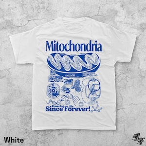 May include: White t-shirt with a blue graphic design featuring the word "Mitochondria" and related scientific illustrations. The phrase "Powering Life Since Forever!" is also displayed.