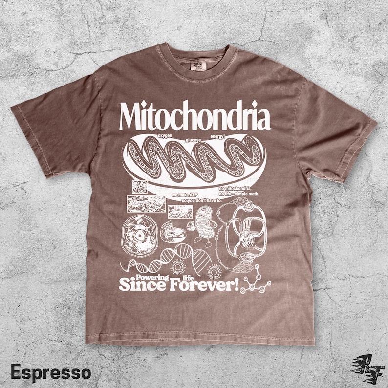 May include: Espresso-colored t-shirt with a white graphic design featuring the word "Mitochondria" and related scientific illustrations. The shirt also includes the text "Powering life Since Forever!"