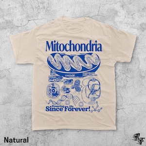 May include: A natural-colored t-shirt with a blue graphic design featuring the word "Mitochondria" and related scientific illustrations. The text "Powering life Since Forever!" is also included in the design.
