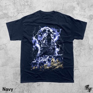 Puede incluir: Camiseta azul marino con un gr&aacute;fico de un lobo aullando bajo la luna llena y rel&aacute;mpagos. El dise&ntilde;o incluye una manada de lobos en un terreno rocoso. La palabra "Navy" est&aacute; impresa en la parte inferior.