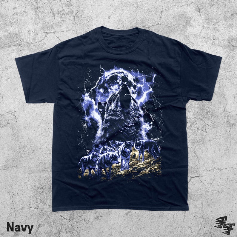 Puede incluir: Camiseta azul marino con un gr&aacute;fico de un lobo aullando bajo la luna llena y rel&aacute;mpagos. El dise&ntilde;o incluye una manada de lobos en un terreno rocoso. La palabra "Navy" est&aacute; impresa en la parte inferior.
