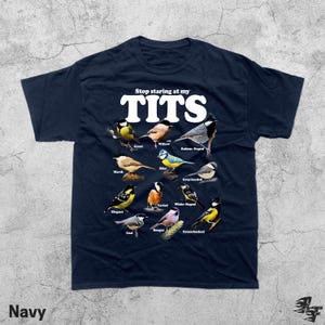 May include: Navy blue t-shirt with the text "Stop staring at my TITS" in white. The shirt features illustrations of various bird species, each labeled with their common names. The word "Navy" is printed at the bottom.