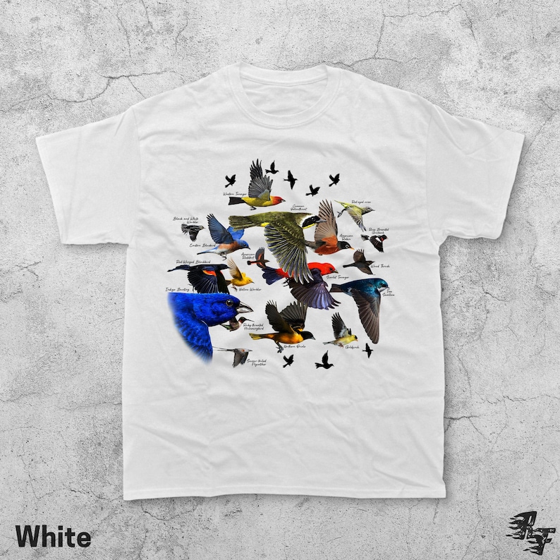 May include: White t-shirt featuring a colorful illustration of various bird species in flight. The design includes detailed depictions of different birds with their names, set against a white background. The word "White" is printed at the bottom.