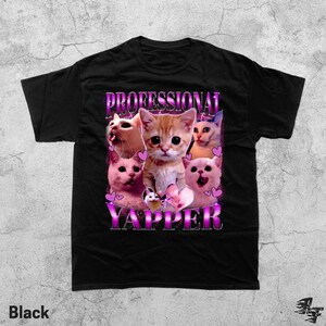 May include: Black t-shirt featuring a graphic of several cats with the text "PROFESSIONAL YAPPER" in a pink and purple font. The cats are in various poses, with hearts around them.