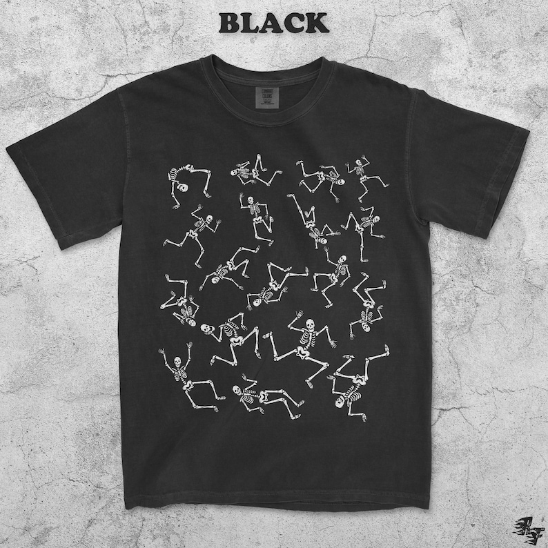 May include: Black t-shirt with a white skeleton pattern. The word "BLACK" is printed at the top. The design features multiple white skeletons in various poses, creating a playful and spooky aesthetic.