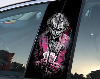 Op de afbeelding: Een autosticker met een gestileerde afbeelding van de Joker die speelkaarten vasthoudt. Het kunstwerk is overwegend zwart, wit en roze, met een donkere achtergrond. De sticker is bedoeld om op een autoruit te worden geplakt.
