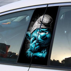 Könnte beinhalten: Grafik eines blauen Schlumpf-Charakters auf einem Autofenster. Der Schlumpf wird mit einem nachdenklichen Ausdruck dargestellt und trägt eine weiße Mütze. Der Hintergrund ist schwarz, und das Bild wird vom Fenster und der Tür des Autos umrahmt.