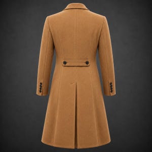 May include: A tan long coat featuring a structured collar, long sleeves with four black buttons at each cuff, and a horizontal back tab detail with two black buttons. The coat includes a central vertical seam and a single back vent at the hem.