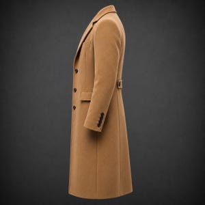 May include: A long, camel-colored overcoat featuring a notched lapel, a single-breasted front with three dark buttons, two side flap pockets, and four smaller buttons on each sleeve cuff. The coat includes a back waist tab with a single button.