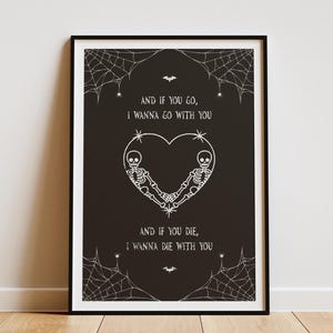 May include: Framed black print with white illustrations and text. The artwork depicts a heart formed by two skeletons holding hands, with spiderwebs and bats. The text reads, "AND IF YOU GO, I WANNA GO WITH YOU. AND IF YOU DIE, I WANNA DIE WITH YOU."