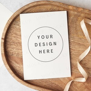 Invitation de mariage ou maquette de carte de voeux avec enveloppe, mise à plat sur une surface en bois. Maquette minimaliste avec ruban. Carte d'anniversaire. Jpeg uniquement