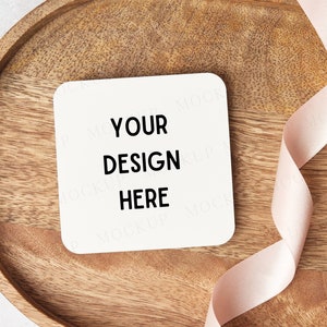 Drink coaster mockup. Square white drink coaster mockup with pink ribbon. Styled flat lay stock photo. Wedding bridal gift mock up.