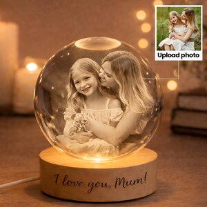 May include: A crystal ball with a photo of a mother and child inside, set on a wooden base. The base is engraved with the words "I love you, Mum!". The image is in sepia tones. The base has a warm, inviting glow.
