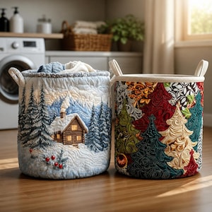 May include: Two cylindrical fabric laundry baskets with handles. The left basket features a quilted winter scene with a log cabin, snow-covered pine trees, and red berries. The right basket displays a colorful pattern of stylized Christmas trees.