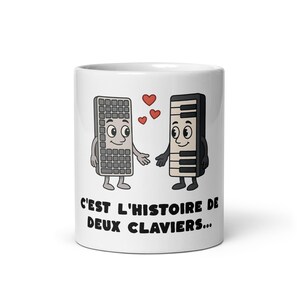 Peut inclure: Mug en céramique blanche avec des personnages de clavier et de touches de piano de dessin animé et des cœurs. Le mug porte l'inscription en français "C'est l'histoire de deux claviers...". Un design amusant et fantaisiste.