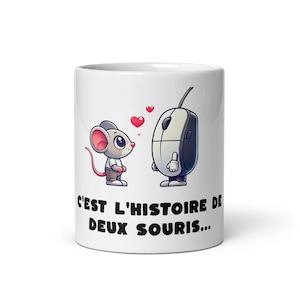 May include: White ceramic mug with a cartoon mouse and a computer mouse design, with hearts between them. The mug has the French text "C'EST L'HISTOIRE DE DEUX SOURIS..." printed on it.