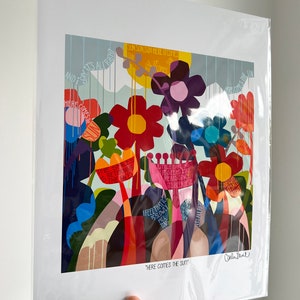 Puede incluir: Una impresi&oacute;n de arte abstracto colorida con un tema floral. La impresi&oacute;n presenta una variedad de flores en tonos de rojo, naranja, amarillo, morado y azul. El fondo es azul claro con acentos blancos y amarillos. El texto "Here Comes The Sun" est&aacute; impreso en la parte inferior de la impresi&oacute;n.