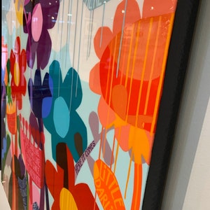 Puede incluir: Una pintura abstracta colorida con un fondo azul, blanco y naranja. La pintura presenta una variedad de flores en diferentes colores y formas. El texto "Here it comes little darling" est&aacute; escrito en la esquina inferior derecha de la pintura.